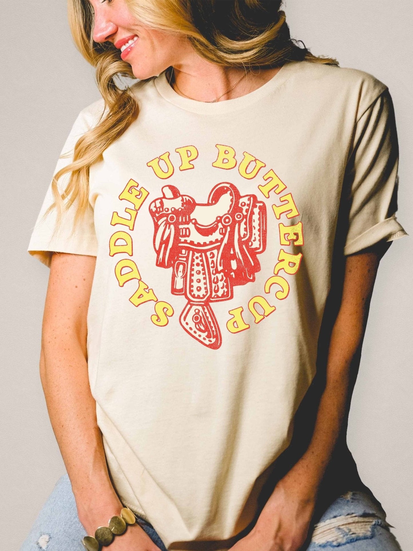 Saddle Up, Buttercup Western Graphic Tee — Hand-Drawn Distressed Cream Cotton Boyfriend Fit (XL remains)